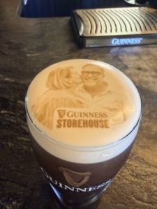 Branded Guinness cup with a foam lid showing a sepia photo and the text 'GUINNESS STOREHOUSE' on the lid/side of the cup.